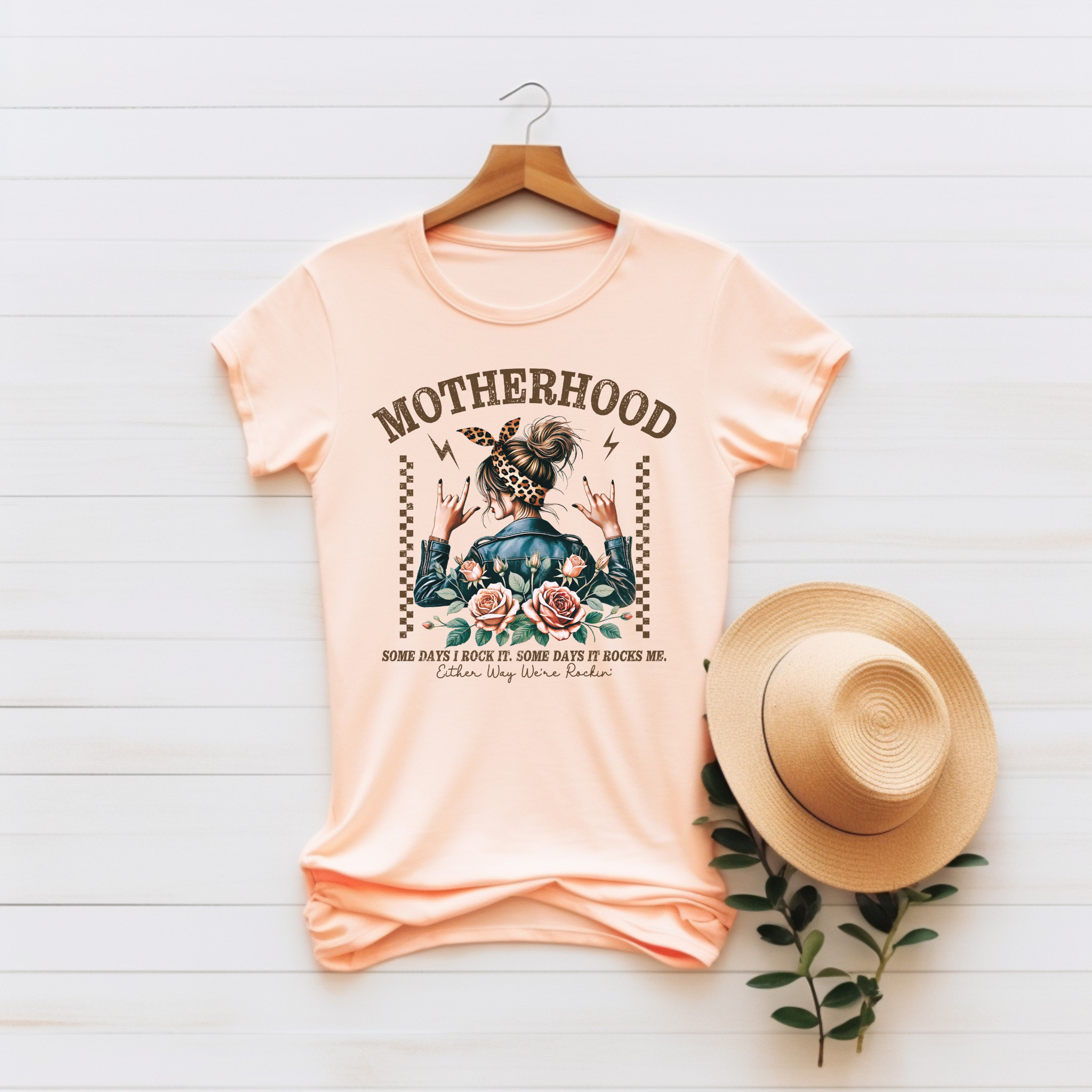 “Motherhood – Some Days I Rock It, Some Days It Rocks Me” Unisex Graphic Tee product thumbnail image