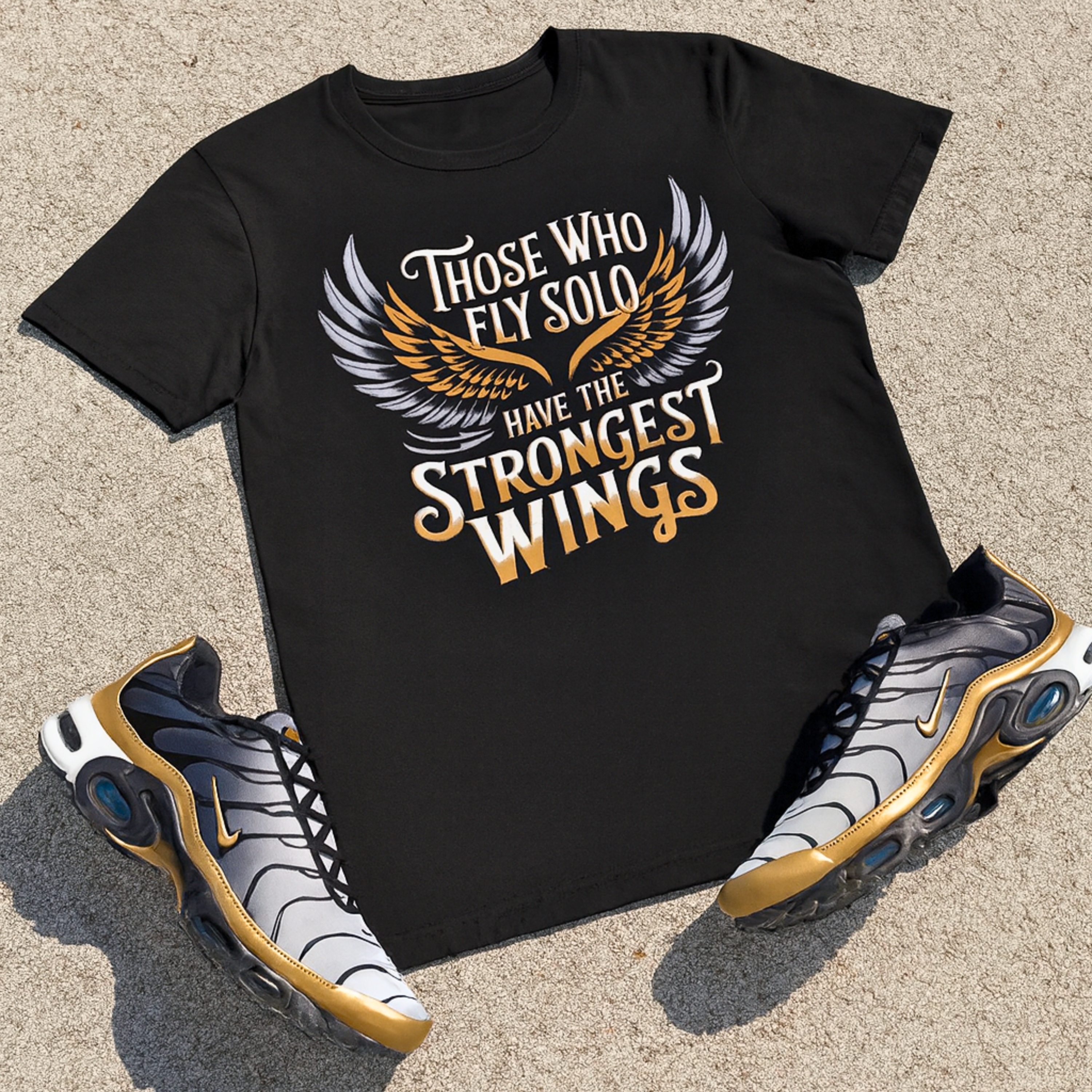  Unisex "Those Who Fly Solo Have The Strongest Wings" Black/Gold/White/Silver Staple Tee. product thumbnail image
