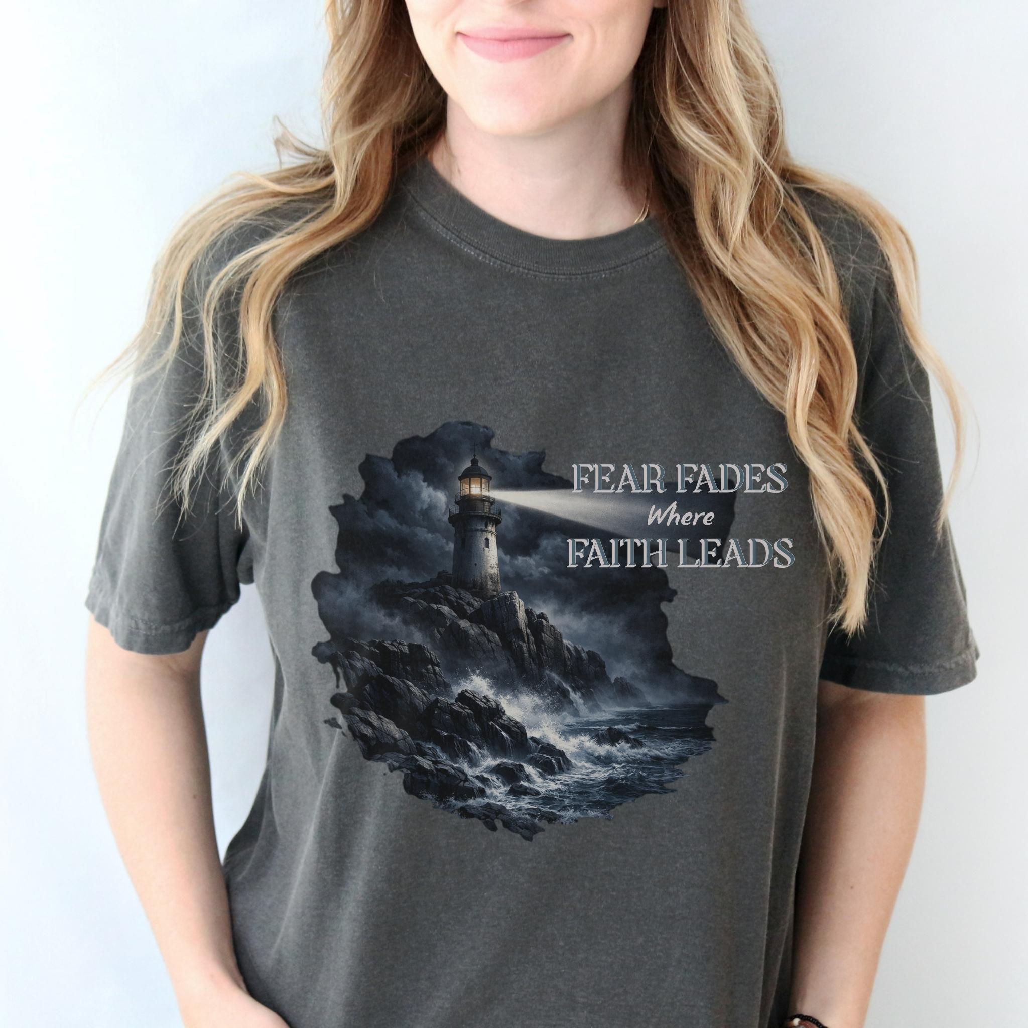 Fear Fades Where Faith Leads | Lighthouse + Storm Shirt – Christian Graphic Tee (Comfort Colors 1717) product thumbnail image Fear Fades Where Faith Leads | Lighthouse + Storm Shirt – Christian Graphic Tee (Comfort Colors 1717) product thumbnail image